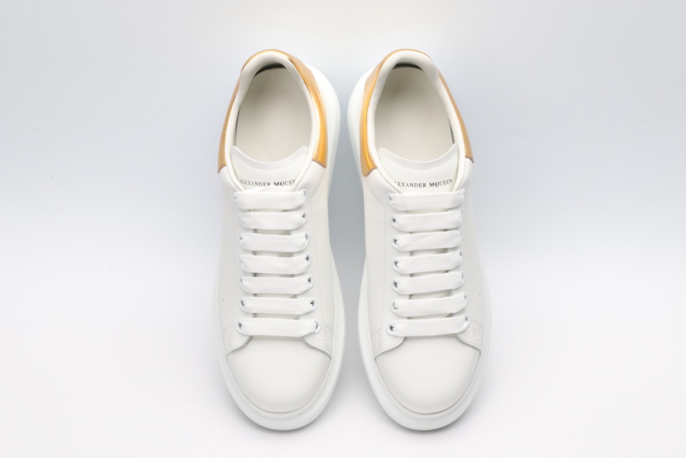 AMQ OVERSIZED SNEAKER with gold grain leather heel